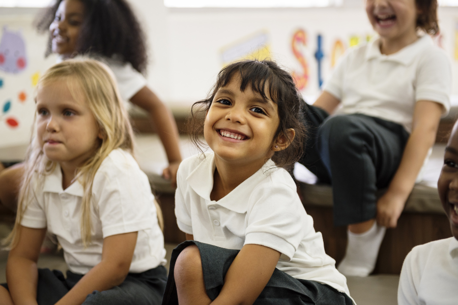 Primary school pupil sitting on carpet in classroom